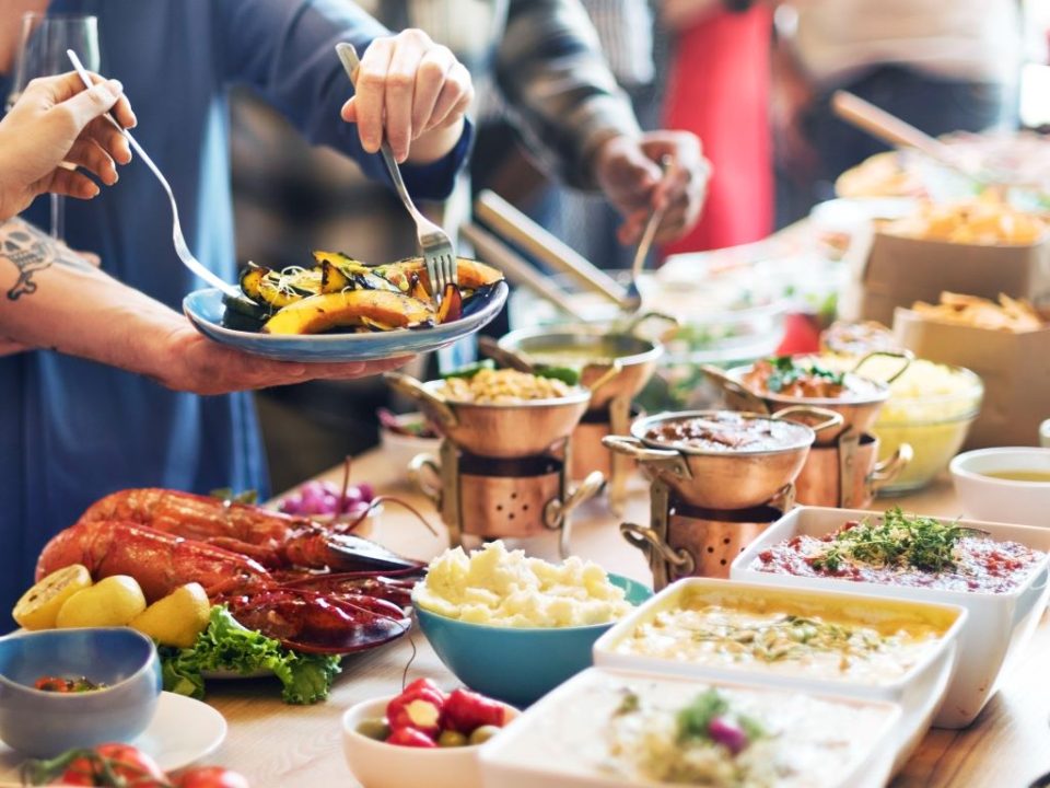 Colorful birthday party food spread with pizza, fruit, and cupcakes arranged on festive table