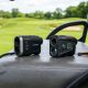 Budget and premium golf rangefinders sitting side by side on a golf cart.