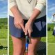 Golfer practicing grip technique using a golf training aid on club