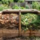 A garden compost bin filled with green grass clippings and brown dry leaves.